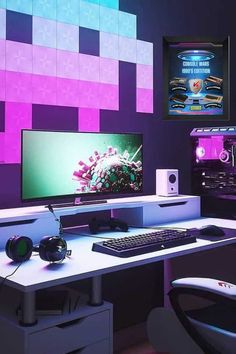 a computer desk with a keyboard, mouse and monitor on it in front of a purple wall