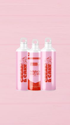 three bottles of orange juice on a pink background