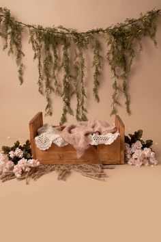 a baby's crib with flowers and greenery hanging from the ceiling next to it