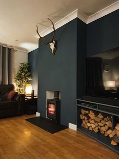 a living room filled with furniture and a fire place in front of a tv mounted on the wall