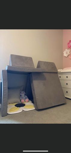 a child's bedroom with a bed made out of concrete blocks and toys on the floor