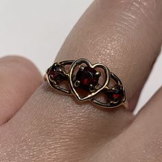 A charming vintage ring with three garnets and a heart detail to the center. Crafted in solid 9ct gold. Hallmarked. In excellent vintage condition. Professionally cleaned & polished.  Comes in a presentation box and will be sent Royal Mail Special Delivery. Refer to images for more information. Size: UK size I 1/2, US size 4 1/2. Weight: 1.4 grams. Vintage Gold Garnet Birthstone Ring, Vintage Heart Ring With Birthstone, Vintage Heart Cut Birthstone Ring, Vintage Heart Cut Birthstone Heart Ring, Vintage Heart Ring With Birthstone For Valentine's Day, Vintage Birthstone Rings For Valentine's Day, Vintage Garnet Birthstone Ring For Anniversary, Vintage Garnet Birthstone Promise Ring, Vintage Garnet Ring