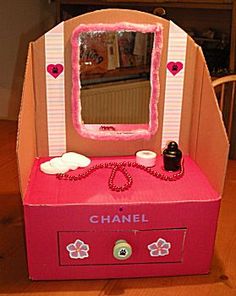 a pink box that has a mirror on top of it with hearts around the edges