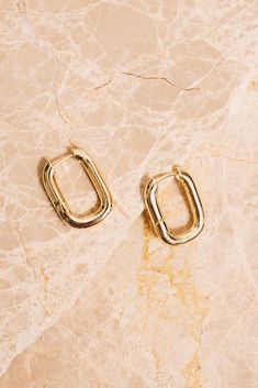 Sleek and shiny with their high polish finish, these minimal rectangular huggie hoop earrings will elevate your everyday look! Dimensions: 1" x 3/4" Materials: Alloy, 18k Gold Plating Ships in a branded jewelry pouch and box, perfect for gift giving! Huggie Hoop Earrings, Jewelry Pouch, Gift Giving, Gold Plating, Everyday Look, 18k Gold, Gold Plate, Silver Rings, Hoop Earrings