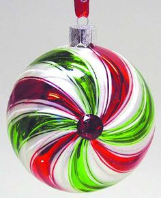 a glass ornament with red, green and white swirls