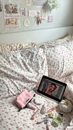 an ipad is sitting on a bed next to other items