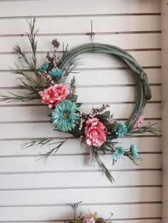 a wreath with flowers hanging on the wall