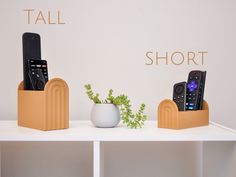 three different types of remotes in wooden holders on a white shelf with the words tall and short above them