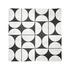 a black and white rug with circles on the front, in an abstract pattern that looks like it has been made out of fabric