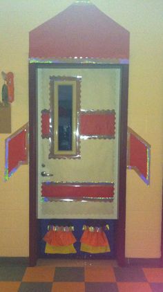 an open door to a room with red and yellow trim on the walls, in front of a mirror