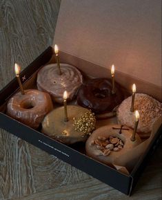 a box filled with donuts and lit candles