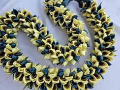 two necklaces made out of yellow and blue ribbons