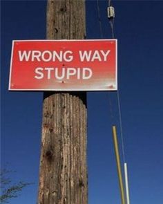 a wrong way sign hanging on a telephone pole