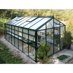 a green house sitting on top of a lush green field