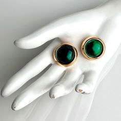 Vintage Oscar De La Renta Emerald Green Gripoix Glass Cabochon Polished Gold Plated Round Clip On Earrings SIGNED. Gorgeous Large Vintage Oscar De La Renta Green Gripoix Clip On Earrings. A Bold Earring By Oscar De La Renta. These Superb Earrings Are Made In Polished Gold Plating And Are Set With A Large Round Emerald Green Gripoix Glass Cabochon. Made Of Gold Plate With Classic Clip On Style Backs. A Stand Out Statement Making Earring. The Emerald Green Glass Is Vibrant; An Eye Catcher. Not For Luxury Vintage Green Clip-on Earrings, Green Cabochon Jewelry For Evening, Round Metal Cabochon Earrings, Elegant Green Round Clip-on Earrings, Green Metal Clip-on Jewelry, Gold Cabochon Clip-on Earrings For Party, Green Clip-on Metal Jewelry, Green Cabochon Jewelry For Party, Bold Earrings