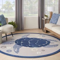 a blue and white rug with a turtle on it in a living room area next to two couches