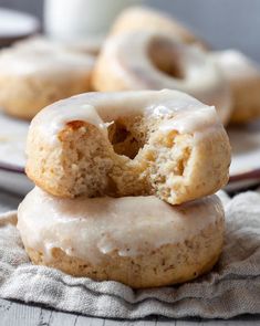 three glazed donuts stacked on top of each other with a cup of coffee in the background