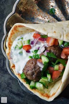 two pita breads filled with meatballs and vegetables