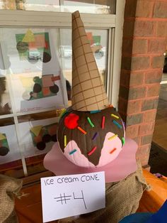 an ice cream cone with sprinkles on it and a sign that says ice cream cone