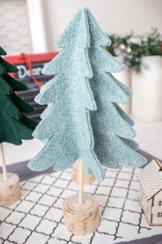 two paper christmas trees sitting on top of a table