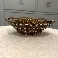 a brown beaded basket sitting on top of a counter next to drawers in a kitchen