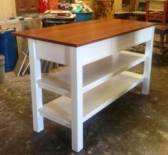 a kitchen island made out of white and wood with shelving on the bottom shelf