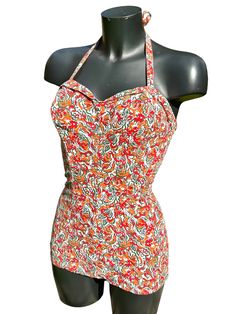 Here we have an original 1950s one-piece bathing suit in fabulous oranges & reds. The front is smooth in style with a little flat 'skirt' across the bottom. The back is entirely ruched. The swimming costume is lined throughout the front and crotch in white cotton. Halter 'tie' neck. Boning in the bra. No makers label... just the remnants of a size label. Sizing.... The mannequin it was photographed on is a  36" bust, 28" waist and 37" hip... The cups look as though they would fit a 'B' cup or ev Fitted One-piece Lined Tankini, Halter Neck Lined Tankini For Swimming, Vintage Fitted Halter Neck Swimwear, Vintage Red Swimwear For Beach, Fitted Orange Swimwear For Swimming, Retro Fitted Halter Neck Swimwear, Retro Halter Neck Tankini For Swimming, Fitted Orange One-piece Swimwear, Retro Halter Neck Fitted Swimwear