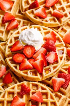 waffles with strawberries and whipped cream on them are ready to be eaten