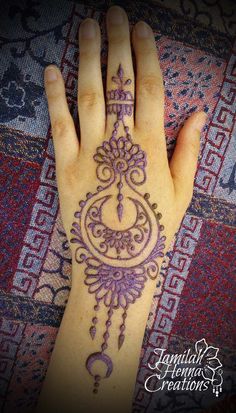 a woman's hand with a henna tattoo on it and an intricate design