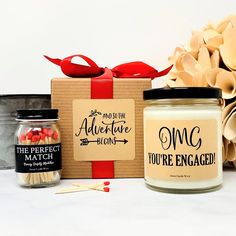 an assortment of candles and matches are sitting next to a gift box with the words adventure, you're engaged written on it