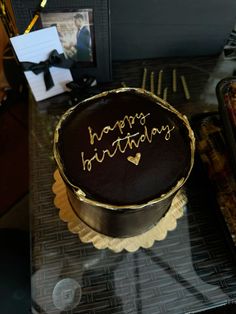 a chocolate birthday cake sitting on top of a table