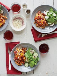 three plates of food on a table with red napkins