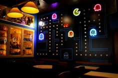 the interior of a restaurant decorated with pacman wallpapers and neon colored lights