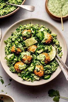 a white bowl filled with green vegetables and meatballs