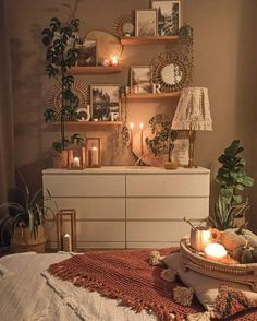 a bedroom with candles and pictures on the wall above it, along with other decorations