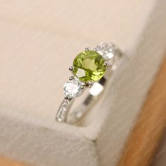 Silver Peridot Birthstone Ring With Accent Stones, Silver Birthstone Ring With Peridot And Accent Stones, Green Peridot Birthstone Ring With Prong Setting, Peridot Diamond Ring For May Birthstone, Lime Green Peridot Birthstone Ring For May, Lime Green Peridot Ring For May Birthstone, Elegant Peridot Birthstone Ring With Prong Setting, Fine Jewelry Peridot Birthstone Ring With Center Stone, Elegant Lime Green Birthstone Promise Ring