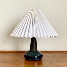 a white lamp sitting on top of a wooden floor