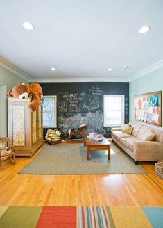 a living room filled with furniture and a chalkboard wall