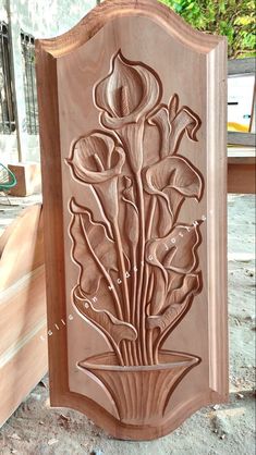 a carved wooden plaque with flowers on it