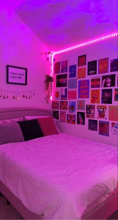 a bed in a room with purple lights on the wall and pictures on the wall