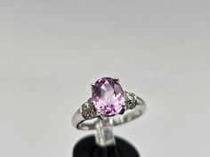 Indulge in the timeless allure of this vintage estate ring, crafted in luxurious 18k white gold. The focal point is a resplendent oval-cut kunzite, boasting a substantial 2.08 carats. Kunzite, known for its positive properties, brings a gentle, soothing energy and is often associated with matters of the heart. The captivating pink hue of the genuine kunzite is cradled in an elegant 4-prong setting, exuding a soft and romantic charm. Adorning the shoulders of the ring are genuine natural diamonds Kunzite Ring, Matters Of The Heart, Bethlehem Pa, Estate Ring, Resize Ring, Estate Rings, Jewelry Appraisal, Aesthetic Beauty, White Gold Rings