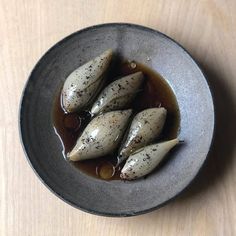 a bowl filled with some kind of food on top of a wooden table