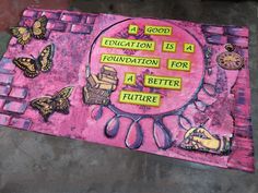 a pink mat with words written on it and butterflies around the perimeter, in front of a concrete floor