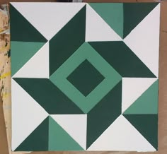 a piece of art that is being made with green and white squares on it's surface