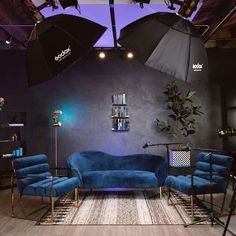 a living room with blue couches and umbrellas