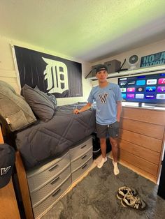 a man standing next to a bed in a room