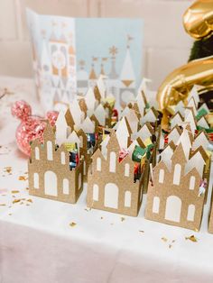 there are many small houses on the table with confetti in front of them