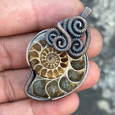 a person is holding a piece of jewelry in their hand and it has two spirals attached to it