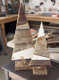 two wooden christmas trees sitting on top of a table