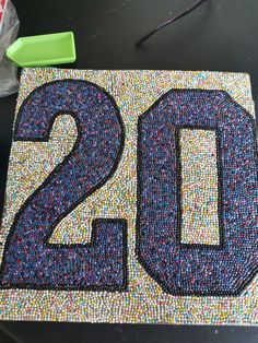 the number twenty two is made out of small beads and sequins on a table